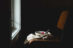 a bowl of fruit sitting on top of a wooden table next to a white cloth