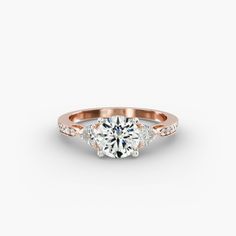 a rose gold engagement ring with two diamonds on the band and an oval center stone