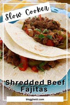 two shredded beef tacos on a plate with the title slow cooker shredded beef fajitas