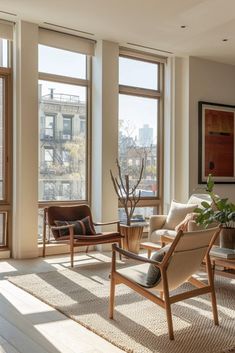 a living room filled with lots of windows next to a wooden table and chairs in front of large windows