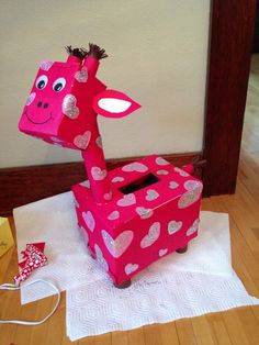 a giraffe made out of tissue paper sitting on top of a table