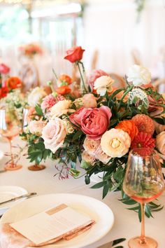 the table is set with flowers and wine glasses