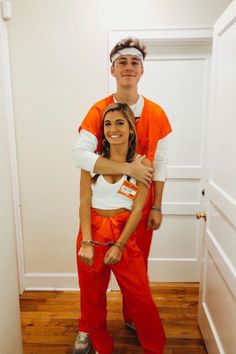 a man in an orange prison outfit is hugging a woman with her arms around him