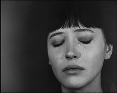 a black and white photo of a woman with her eyes closed