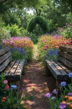 a pathway lined with wooden benches surrounded by colorful wildflowers and greenery in the background