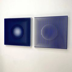 two blue paintings are hanging on the wall