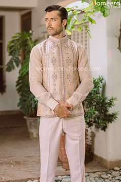 Kurta Design Mens Sherwani Waistcoat Wedding Dress is not only a traditional silhouette but an ensemble that not only validates the beauty of a man but also celebrates his passion and magnificence. Groom will wear an ivory silk waistcoat with eye-catching sheesha work with resham. Worn on too of tailored pants. Waistcoat: Glamour meets opulence in this ethereal and pink groom masterpiece. The signature motifs are derived from visually divine blossoms that are hand embroidered and embellished wit Peach Sherwani, Wedding Kurta For Men, Mens Sherwani, Men's Waistcoat, Kurta Design, Gul Ahmed, Groom Wear, Ivory Silk, Kurta Designs