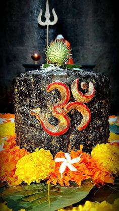 a decorated cake sitting on top of a table next to flowers and an om shan