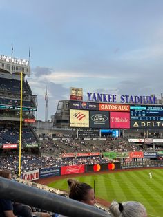 a stadium filled with lots of people sitting in the bleachers and watching baseball