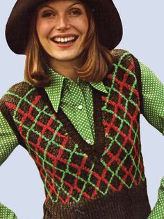 a woman wearing a green and red sweater with a black hat on top of her head