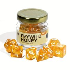 a jar filled with yellow and white dice next to it's contents on a white surface