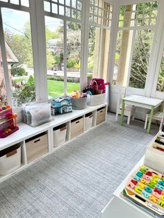 a child's playroom with toys and storage bins on the windowsill