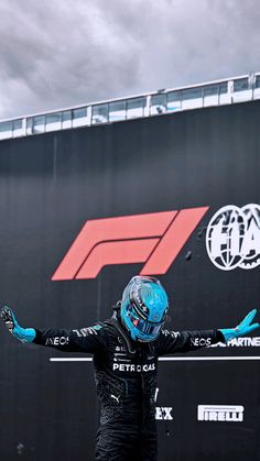 a man with blue paint on his face standing in front of a race car sign