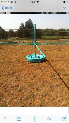 an image of a blue object in the middle of a fenced off area with grass