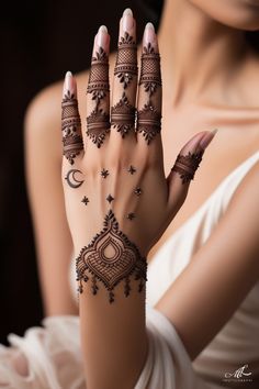 a woman's hand with hennap and tattoos on her hands, showing the design