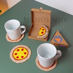 the coasters are made to look like they have pizza slices on them, along with two cups and saucers