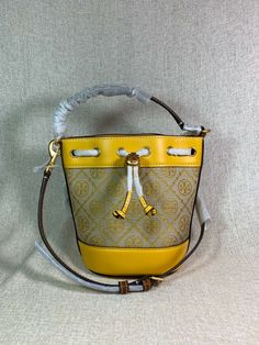 Please see all 12 pictures and read the entire description before placing your order. You Are Looking At A Gorgeous Goldfinch T Monogram Jacquard/Leather MINI Bucket Bag By Tory Burch AUTHENTICITY NOTE: These jacquard T Monogram Mini Bucket Bags are MADE IN VIETNAM. The ones that have the interior white labels that say MADE IN CHINA are fake. FAST SHIPPING !!! ARRIVES IN 2-3 BUSINESS DAYS !! Visit my store for a wide selection of beautiful leather bags CLICK HERE ---> Visit My eBay Store Monarco Luxury Yellow Bucket Bag For Travel, Designer Tan Bucket Bag, Luxury Yellow Bucket Bag With Removable Pouch, Tt Logo, White Labels, T Monogram, Mini Bucket Bag, Mini Bucket, Mini Bucket Bags