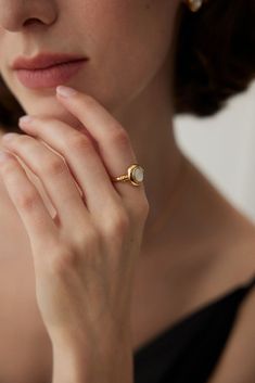 a close up of a person wearing a ring with a pearl on it's finger