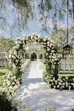 an outdoor ceremony with white flowers and greenery