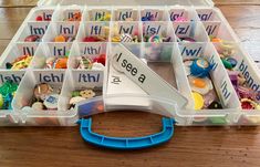 a plastic container filled with lots of different types of toys and letters on it's lid