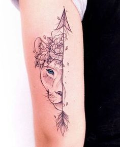 a woman's arm with a deer head and arrow tattoo on the left side of her arm