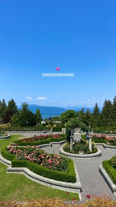 the garden is surrounded by beautiful flowers and greenery with blue skies in the background