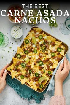 the best carne asada nachos recipe is shown with hands holding a dish