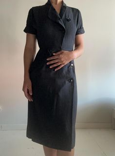 This dress is classic, and it has a beautiful fit. I sourced this is San Francisco. It's in perfect condition, not a button out of place. I believe the dress is 100% cotton. Please reach out with any questions.  Measurements Shoulder: 14 inches Sleeve length: 7 inches  Waist: 13 inches Hip: 18.5 inches Length: 42 inches Bottom opening: 22 inches PLEASE READ MEASUREMENTS *All items are measured flat. Measurements are not doubled.* EXCHANGE/STORE CREDIT ONLY Please view return policy DISCLOSURE Some items have been professionally cleaned and altered. Photos and measurements reflect the current state of the item. All additional care is the responsibility of the buyer. Formal Button-up Dress With Buttons, Fitted Dresses With Button Closure For Work, Classic Dresses With Button Closure For Daywear, Fitted Office Lady Dress With Buttons, Classic Fitted Shirt Dress With Covered Buttons, Classic Fitted Shirt Dress With Buttons, Classic Fitted Shirt Dress With Button Closure, Fitted Short Sleeve Shirt Dress For Semi-formal, Fitted Short Sleeve Shirt Dress For Semi-formal Occasions