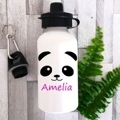 a water bottle with a panda face on it and a keychain next to it