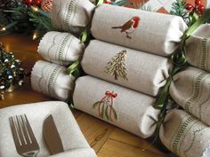 a stack of christmas napkins sitting on top of a table next to a fork and knife