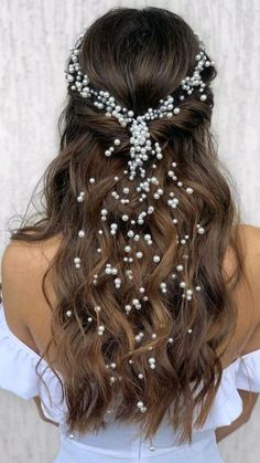 the back of a woman's head with pearls in her hair