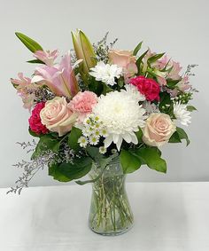 a vase filled with lots of pink and white flowers