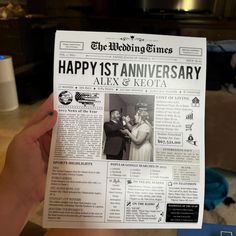 a person holding up a newspaper with the words happy 1st anniversary alex and keota on it