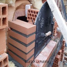 an outdoor oven made out of bricks in the middle of some construction materials and cement