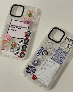 two cell phones with stickers on them sitting next to each other in plastic cases