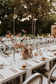 the tables are set with white linens and place settings for an outdoor wedding reception