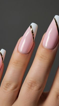 a woman's hand with pink and white nail polish on her nails, gold ring