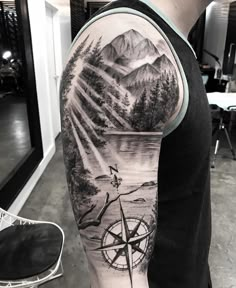 a man with a bicycle and mountains tattoo on his arm