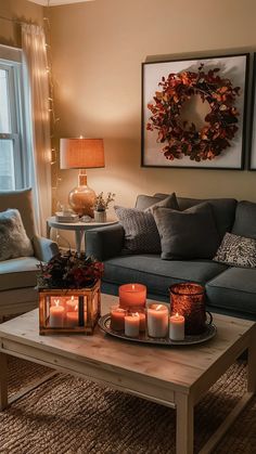 a living room filled with furniture and candles on top of a coffee table in front of a window