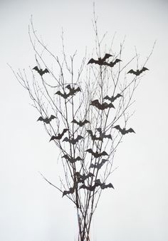 a vase filled with branches and bats on top of it