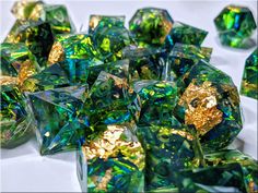 many green and gold colored dices on a white surface