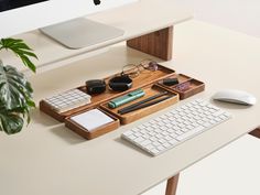 a computer desk with a keyboard, mouse and glasses on it