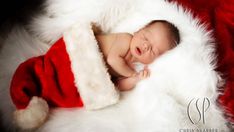 a baby in a santa hat is laying down