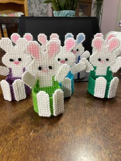 several small plastic rabbits sitting on top of a wooden table