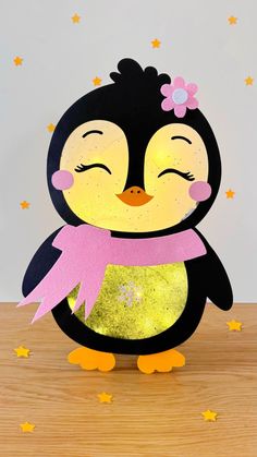 a paper cut out of a penguin wearing a pink scarf