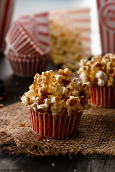 three red and white striped cupcakes with popcorn on the top one is half eaten