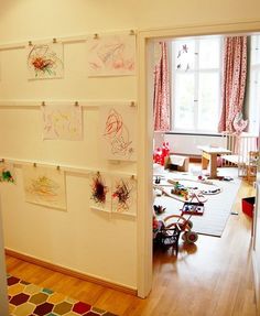 there are many drawings on the wall in this child's room, but no one is using them