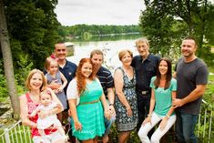 a group of people standing next to each other in front of a body of water