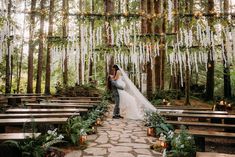 a bride and groom standing in the middle of a forest