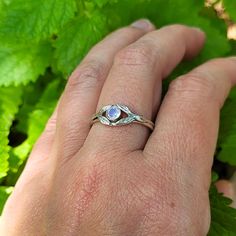 This magical rainbow moonstone ring enchants the senses with its prismatic stone surround by tiny leaves set on a band that looks like it was forged within an enchanted forest. Each ring is handmade specifically for you where a hand-wrought recycled sterling silver split-shank band is adorned with tiny detailed leaves that surround a round faceted rainbow moonstone that reflects the light with unexpected flashes of color. This nature-inspired rainbow moonstone ring could be a non-traditional gem Hand Forged Moonstone Jewelry For Promise Ring, Hand Forged Moonstone Ring Gift, Hand Forged Moonstone Ring For Gift, Mystical Hand Forged Moonstone Ring For Gift, Mystical Hand-forged Moonstone Ring As Gift, Hand Forged Spiritual Round Moonstone Ring, Ethereal Moonstone Rings With Birthstone, Hand Forged Spiritual Moonstone Ring, Nature-inspired Round Moonstone Ring In Sterling Silver